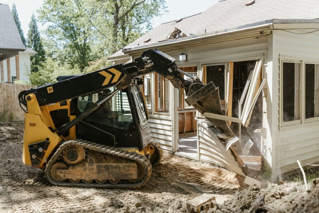 Demolition contractor tearing down an old garage.
